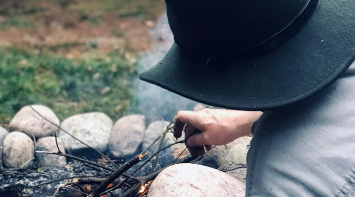 Person tending to the campfire in ny state